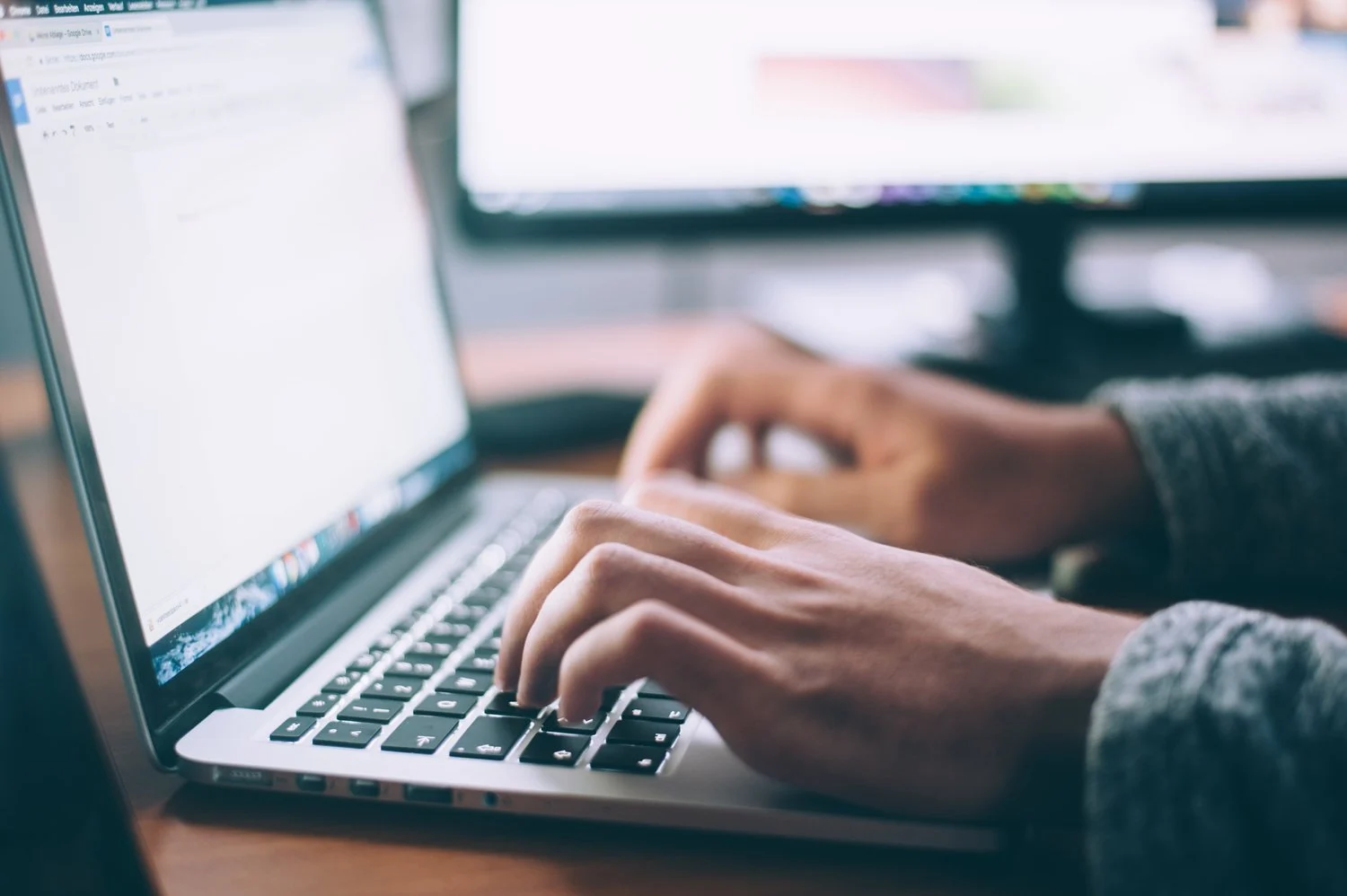 Person working on a laptop at a desk.