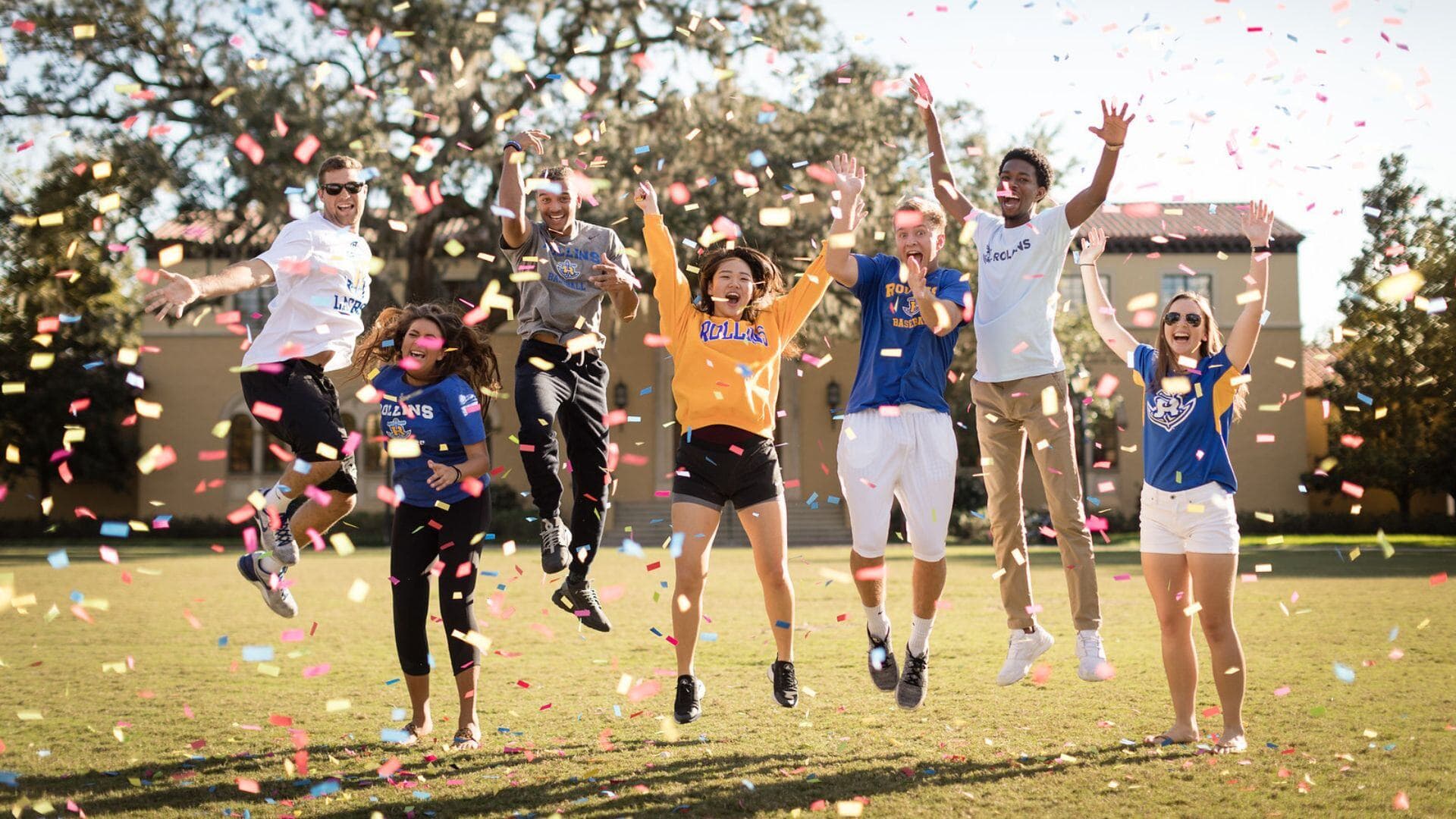Rollins College students celebrating outdoors with confetti.